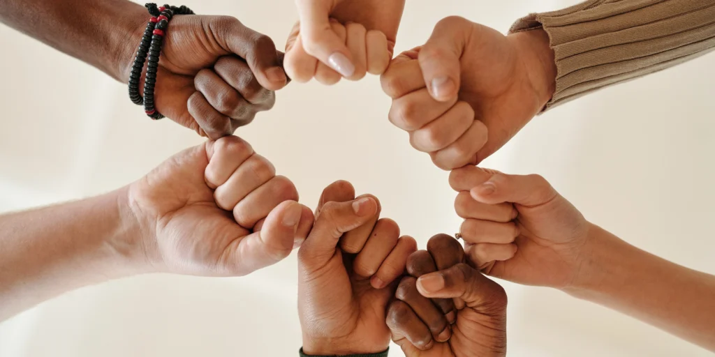 A team of diverse individuals sharing a fist bump in unison Image by Diva Plavalaguna | Source: Pexels.com